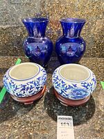 two cobalt blue vases and two porcelain planters on stands overall view