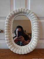 Front view of white wicker oval mirror