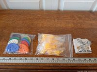 Overall view of three sealed packages: sensory stones, squishy ducks, LED spinner with ruler for scale