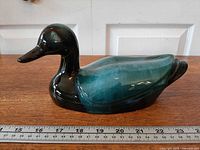 Left profile of drip-glaze mallard figurine with ruler for scale