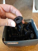 Open Unbrako box showing multiple black alloy steel flat socket head cap screws