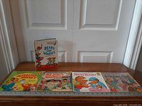 All five books laid flat with ruler for scale