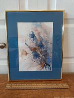 Full view of framed watercolor with ruler for scale