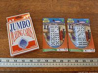 Overall lot: two Montoy dice sets and jumbo playing cards adjacent to ruler