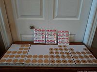 Overview of three sealed packs and multiple loose sheets of round stickers
