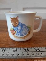 Front view of mug showing mouse illustration and size reference