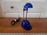 Full view of blue IKEA Espressivo desk lamp with cord and measuring tape for scale