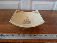 Square stoneware bowl top view showing floral design and ruler for size