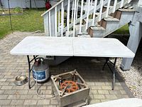 Full top view of folded-out Cosco plastic table on patio