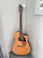 Front view of Fender CD-60SCE guitar standing upright