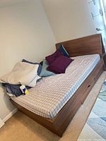 Full view of assembled queen storage bed with mattress and drawers visible