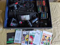 Open carry case showing console, controllers, cartridges, manuals