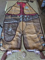 Full view of apron with both toy pistols and badge
