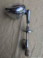 Full view of spotlight showing housing, arm, mount and handle