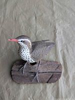 Full view of carved songbird on wooden base