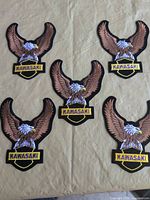 Front view showing five identical Kawasaki eagle patches