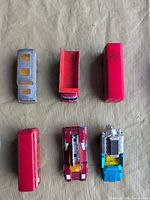 Top view showing roofs/beds of grey coach, tipper bed and red bus
