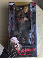 Front of boxed 18-inch Freddy Krueger figure showing graphics and window displaying figure