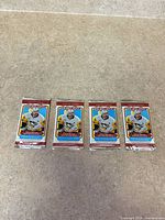 Front view of four sealed O-Pee-Chee 2025-26 hockey packs lined up