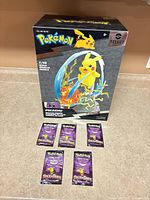 Front view of boxed Pikachu Light FX figure with five sealed booster packs