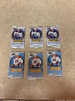 Six sealed Upper Deck hockey card packs arranged, three Series One top row, three Series Two bottom row
