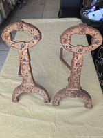 Full view of both cast iron andirons showing overall design and condition