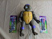 Front view of Donatello figure flanked by two pencil packs