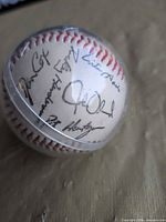 Close-up of printed signatures on baseball inside display case