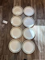 All eight dinner plates displayed face up showing uniform pattern and quantity