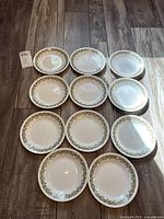 Eleven Corelle side plates arranged face up showing pattern
