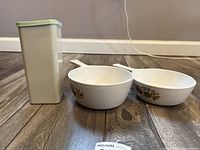 Overall view: two handled bowls and storage canister with lid
