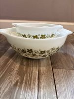 Stacked view of all three green floral Pyrex bowls