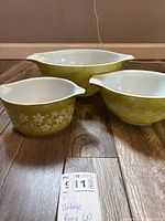 Three green floral Pyrex bowls nested, showing pattern and size comparison