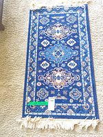 Blue ornate area rug full view with fringe