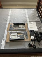 Adjustable base covered in grey fabric with hardware packs, power pack, remote and manual laid on top