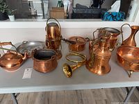 All eight copper and brass items arranged on table