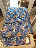 Blue silk-satin dragon motif duvet cover folded on table