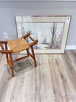 Stool in front of framed landscape print