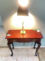 Top view of mahogany side table with lamp seated on top