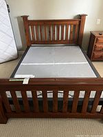 Full view of assembled queen bed frame showing headboard, footboard, side rails