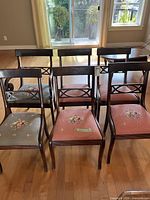 Front view of six mahogany dining chairs with mixed needlepoint seats