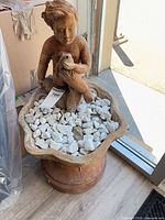 Full view of terracotta cherub fountain statue with basin and stones