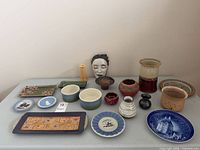 All fifteen ceramic items arranged on table for full lot view
