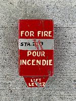 Exterior of red fire alarm cover showing bilingual text and STA.23 label