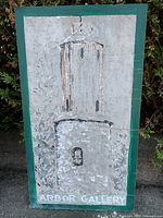 Full front view of painted wood sign showing tower and text