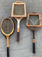 All three wooden racquets, two with presses