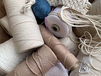 Close-up of various thread cones and ball inside basket