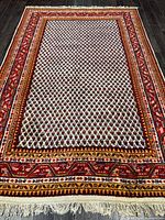 Full view of handmade Boteh pattern rug showing field, borders and fringe