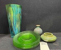 Full lot showing drip art glass vase, stack of six green plates and two pottery pieces