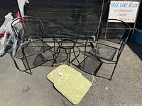 full view of table, two chairs, and cushion on ground